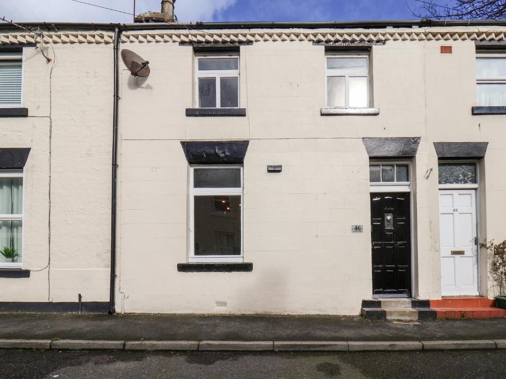 ein weißes Backsteinhaus mit einer schwarzen Tür in der Unterkunft 46 St Mary's Walk in Scarborough