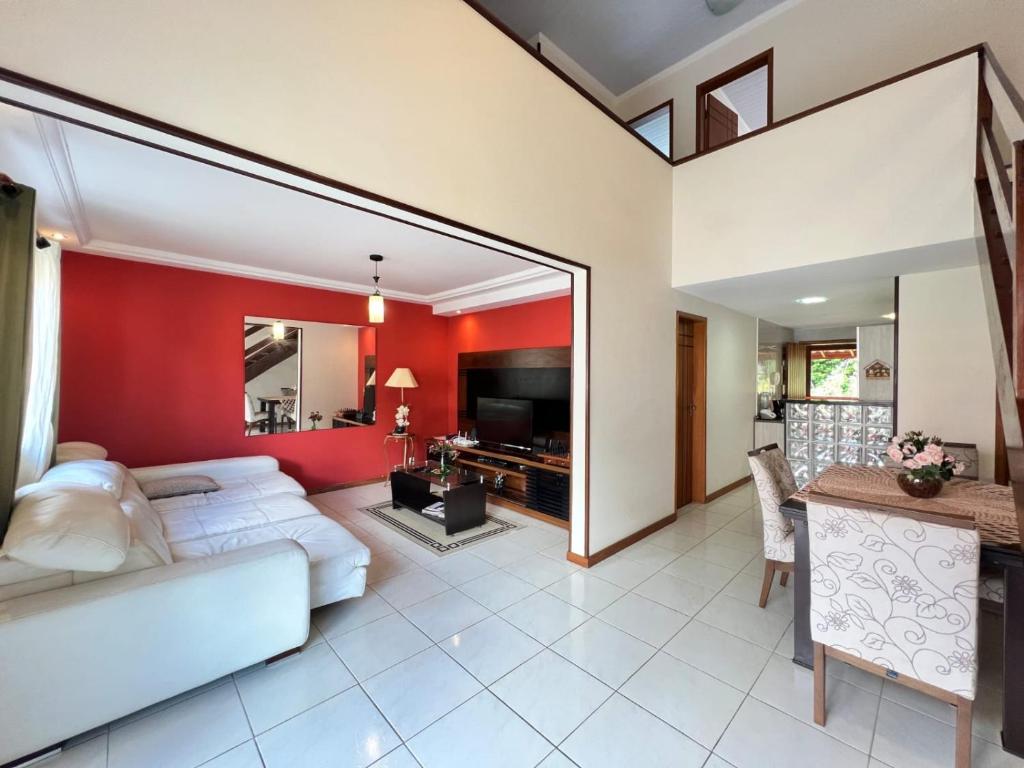 sala de estar con sofá blanco y pared roja en Chamego em Teresópolis próximo a feirinha, en Teresópolis