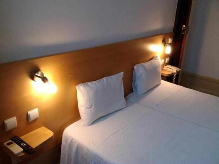 コインブラにあるインテルナシオナルのベッドルーム1室(白いベッド1台、枕2つ付)
