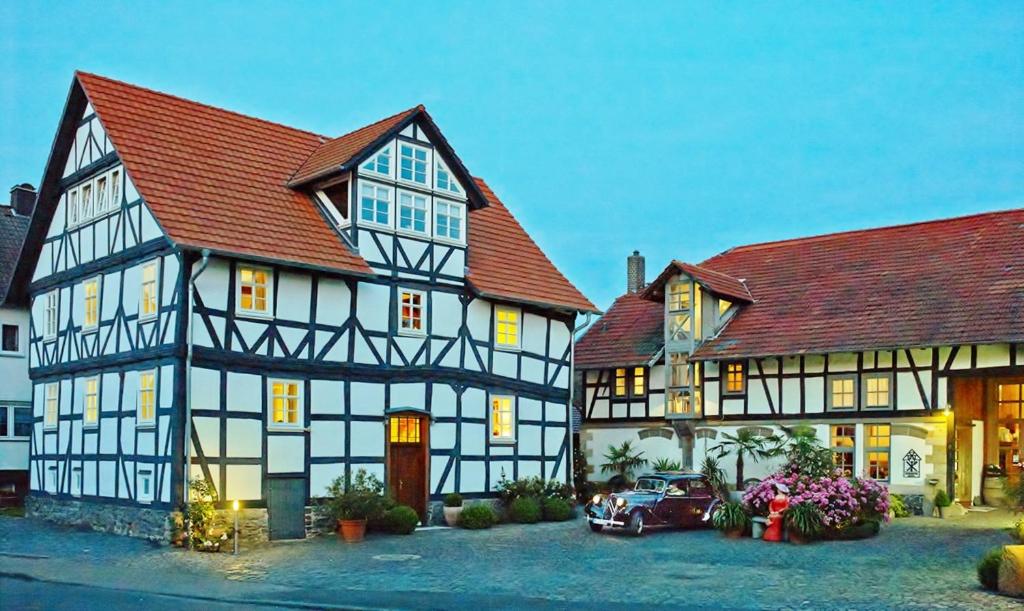 a house with a car parked in front of it at Romantik Hotel Zum Rosenhof in Hesserode