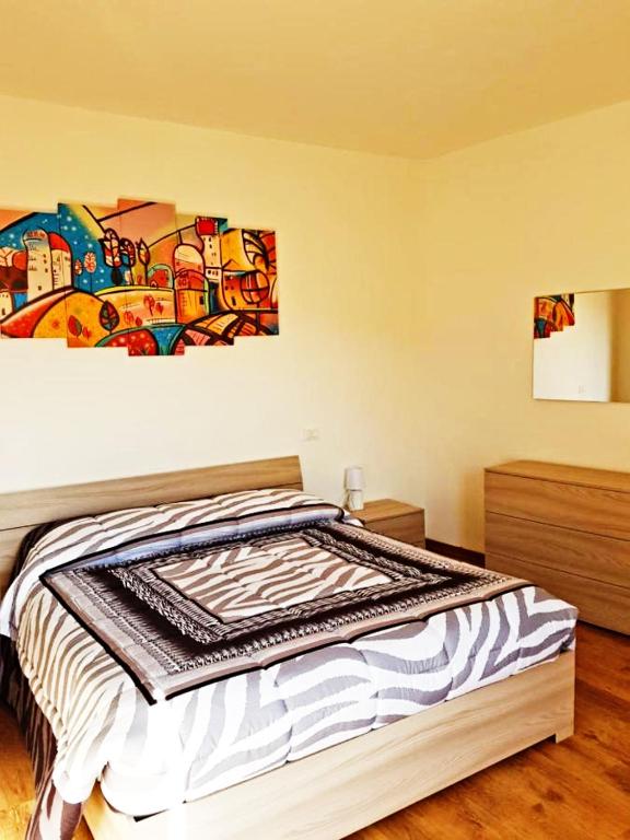 a bedroom with a bed with a painting on the wall at BORGO NEL TEMPO in Collestatte