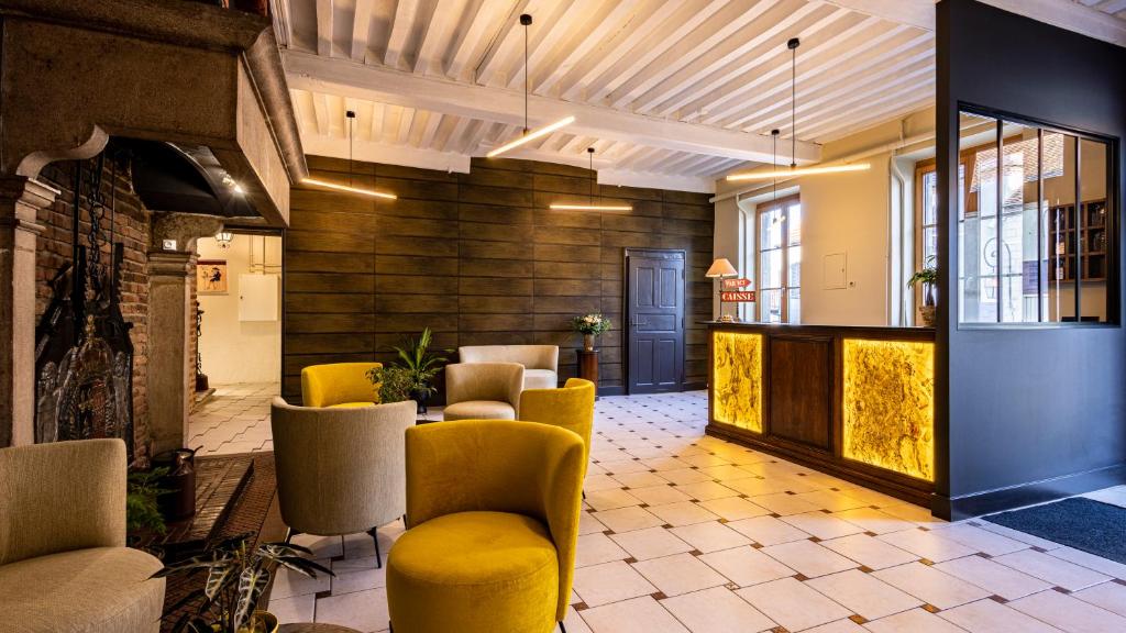 a lobby with yellow chairs and a waiting room at Logis Hostellerie Bressane in Saint-Germain-du-Bois