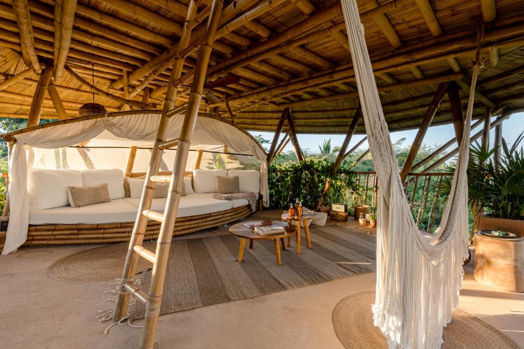 1 dormitorio con 1 cama con dosel y 1 hamaca en Bamboo Tree House romantic & luxury retreat, en Brisas de Zicatela