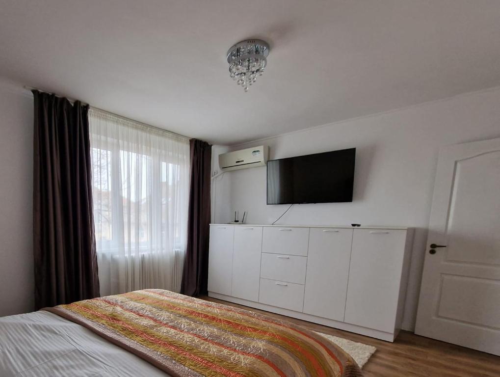 a bedroom with a bed and a flat screen tv at PREFECTURE APARTMENTS in Timişoara
