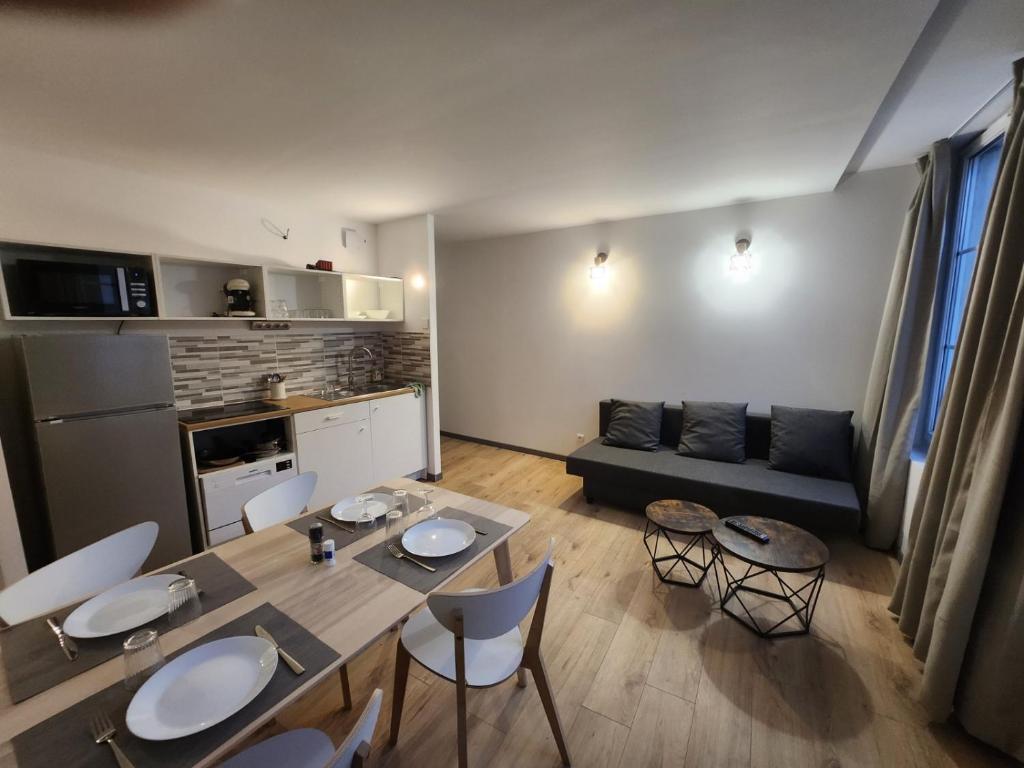 Agréable appartement, lumineux في بار لو دوك: مطبخ وغرفة معيشة مع طاولة وكراسي