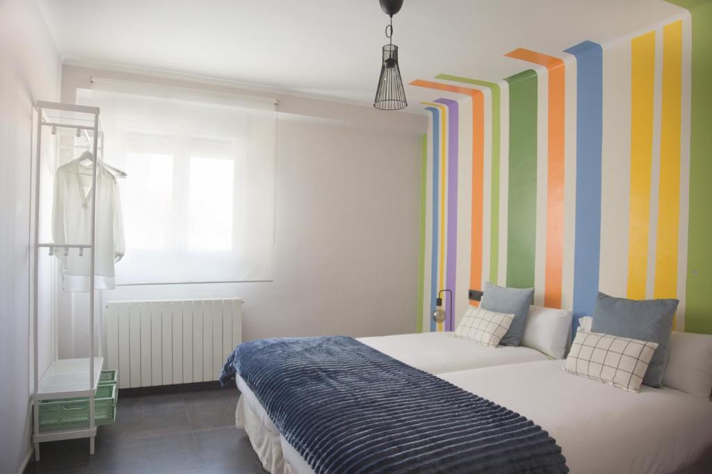 1 dormitorio con 1 cama y una pared colorida en Tauste Centro - Piso, en Tauste