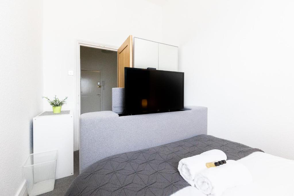 a room with a bed and a flat screen tv at Judah Suites by Koya Homes - TV Bed Apartment, Central High Street, Free Parking in Barry