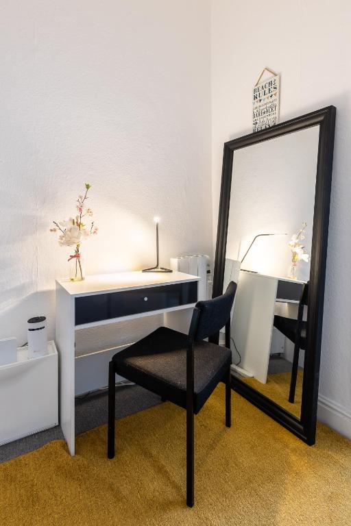 a mirror and a desk and a chair in a room at Judah Suites by Koya Homes - TV Bed Apartment, Central High Street, Free Parking in Barry