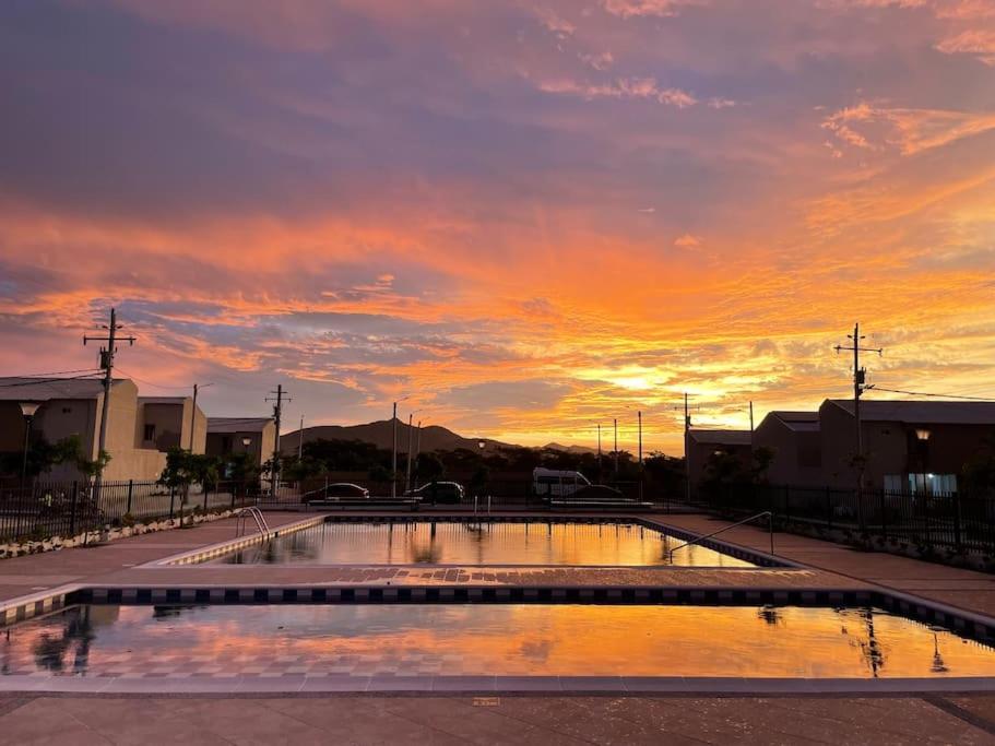 una piscina de agua con una puesta de sol en el fondo en Casa ideal vacaciones o trabajo, en Santa Marta