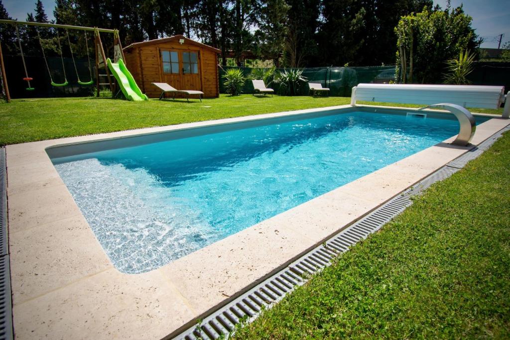 a swimming pool in a yard with a slide at Le gite de Fa nny Moulin de Tartay en Avignon in Avignon