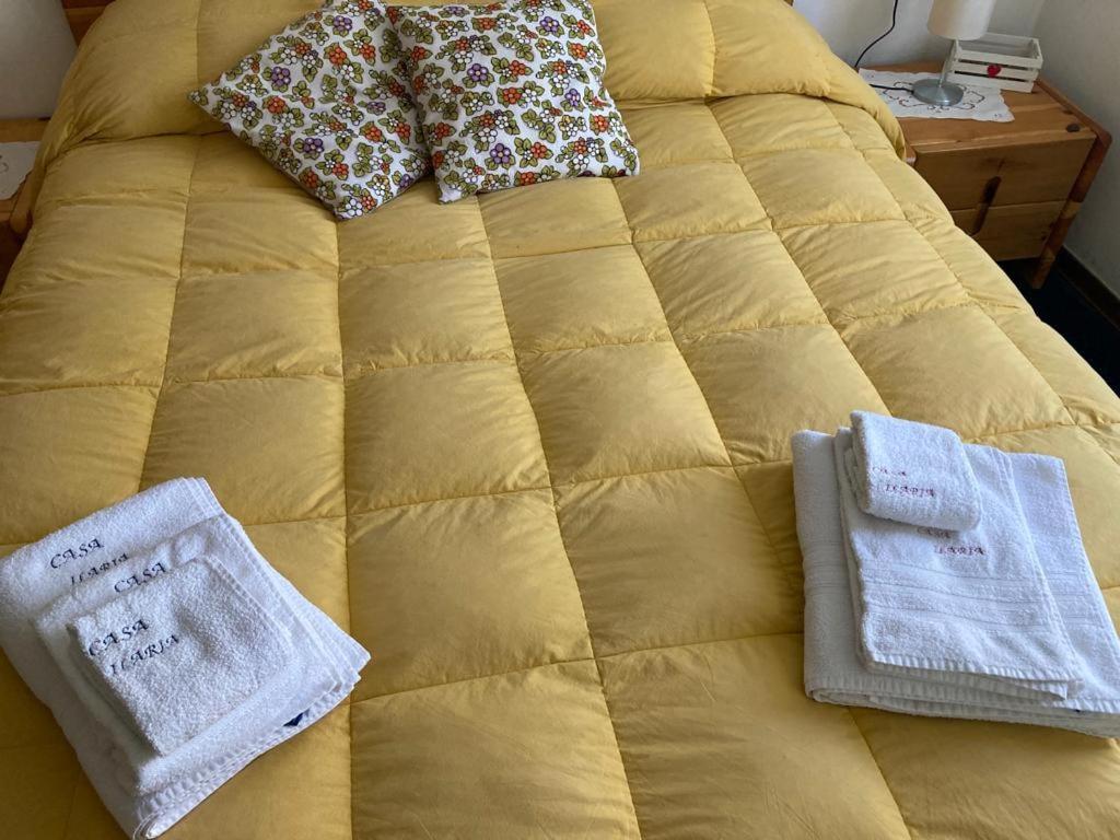 ein gelbes Bett mit Handtüchern darüber in der Unterkunft CASA ILARIA in Faidello