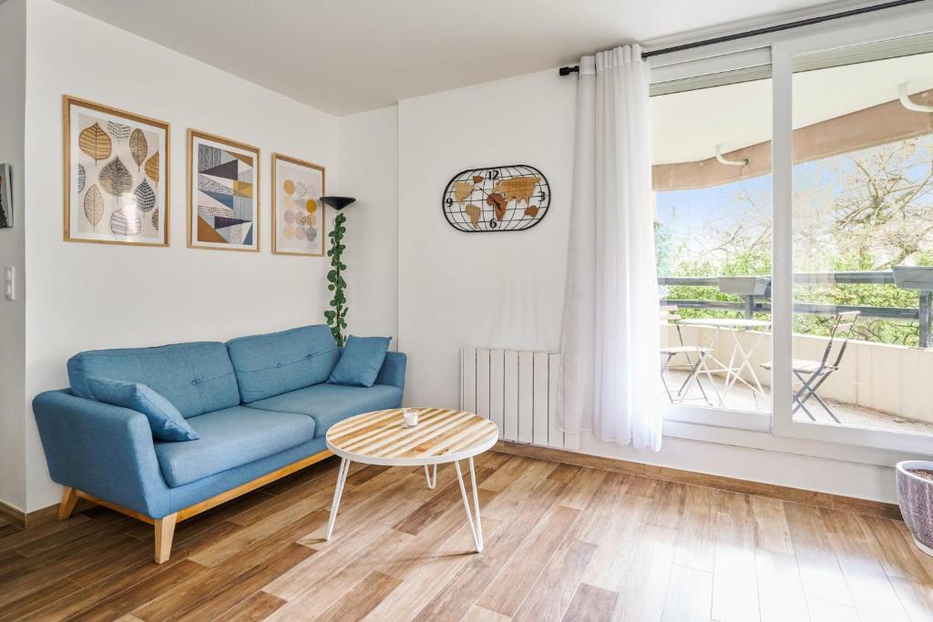 a living room with a blue couch and a table at Charming 1br with terrace close to Paris - Asnières - Welkeys in Asnières-sur-Seine