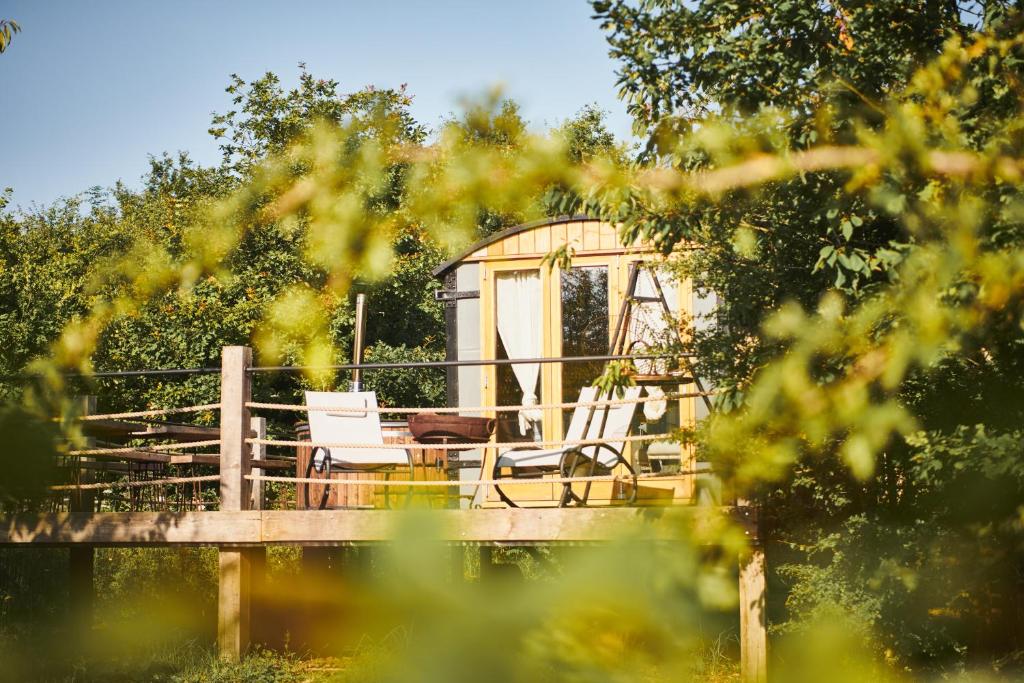 einen Pavillon mit zwei Stühlen und einem Tisch auf einer Brücke in der Unterkunft Nature's Spectacular in Chew Stoke