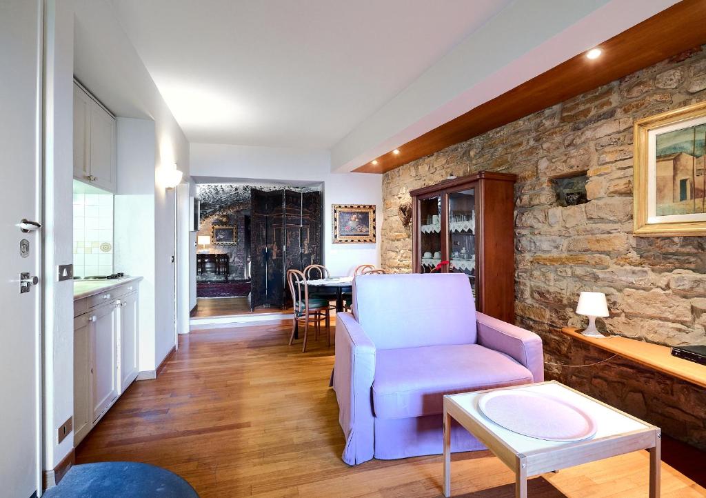 un soggiorno con una sedia blu e un muro in pietra di CasaBlanca charme & relax a Bergamo