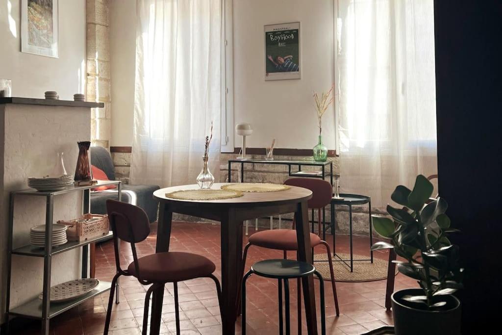 una habitación con mesa y taburetes en Studio au cœur du centre ville d’Avignon, en Aviñón