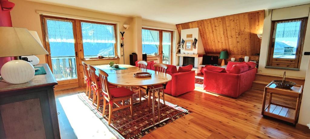 a living room with a table and red chairs at Hostdomus - Rooftop Deluxe Suite in Sestriere