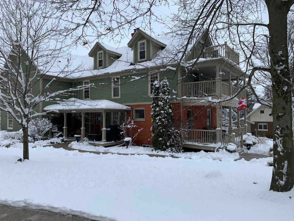 duży zielony dom z śniegiem na ziemi w obiekcie The Red Coat w mieście Niagara-on-the-Lake