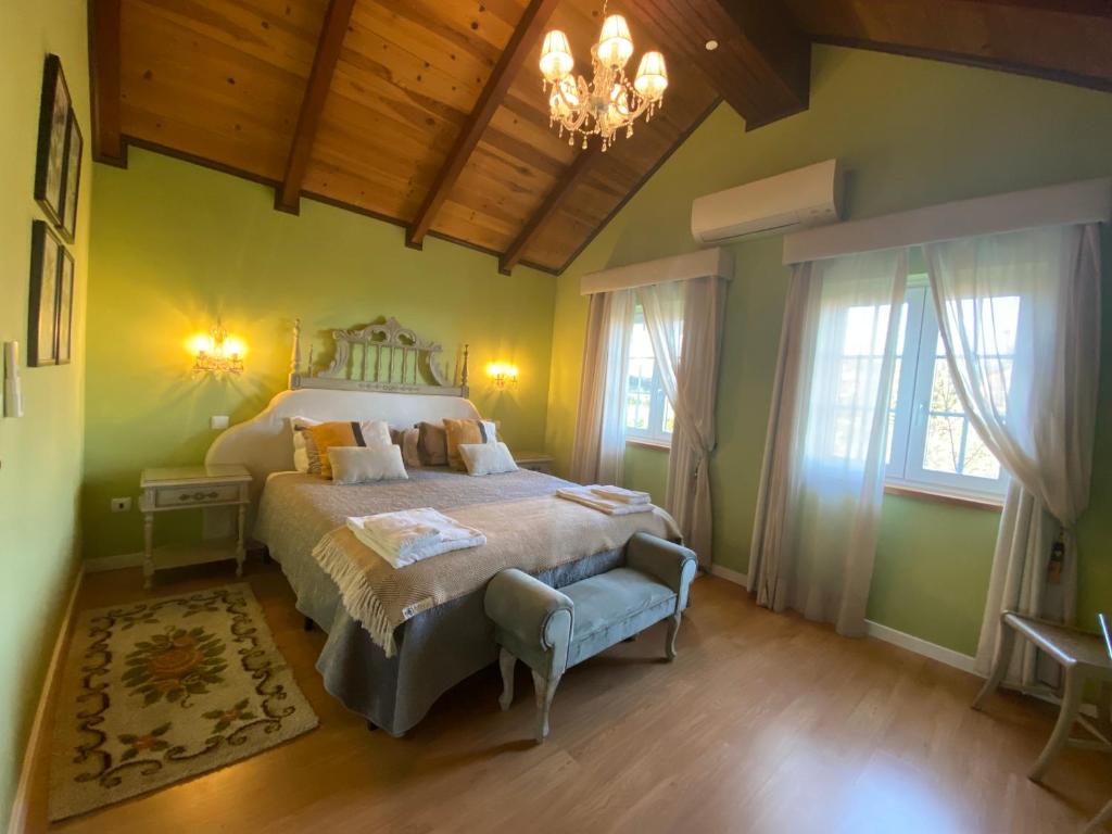 a bedroom with a bed and a chandelier at Villa Silene in Covilhã