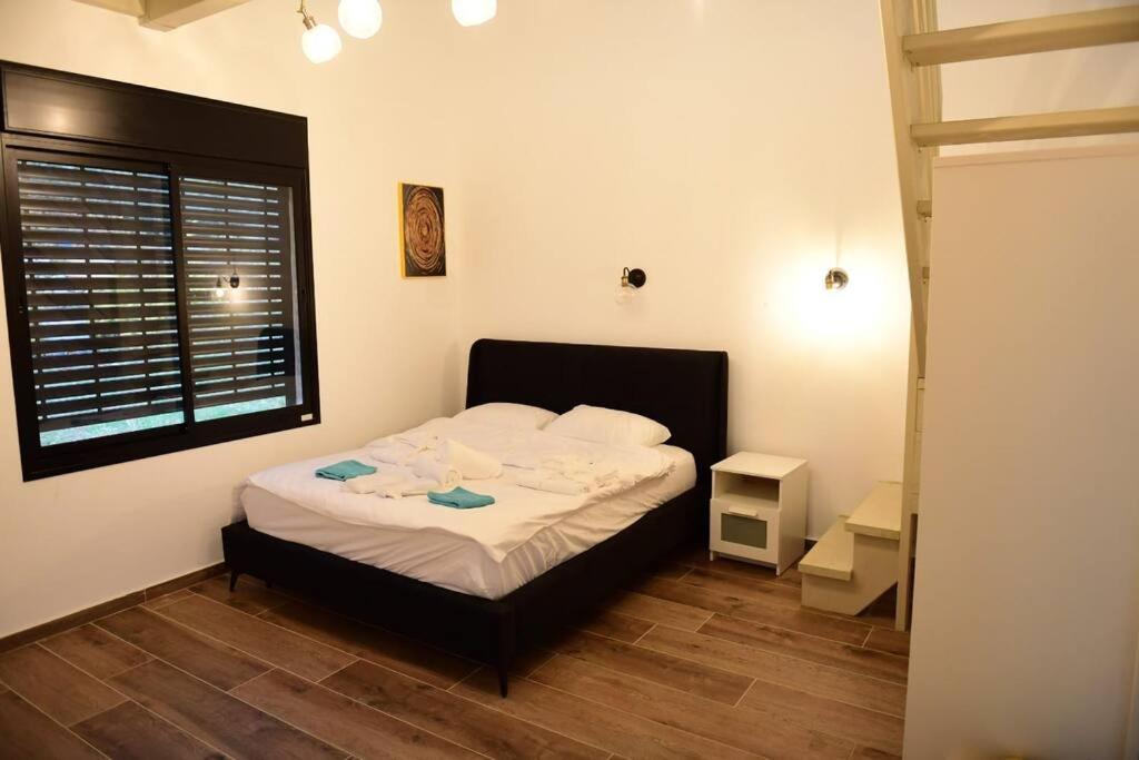 a bedroom with a bed in a room with a window at ממלכת החלומות - וילה מושלמת עם ממ"ד בריכה פרטית ונוף גליל in ‘Ein el Asad