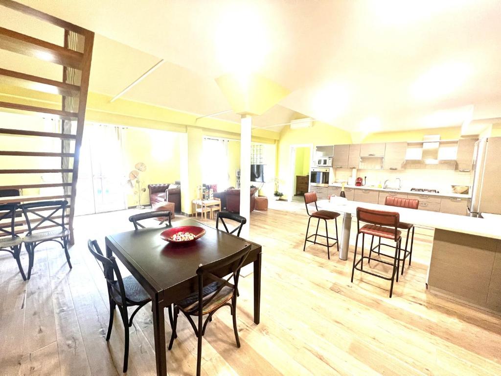 a living room with a table and chairs and a kitchen at Attico Darsena Nuova in Ravenna