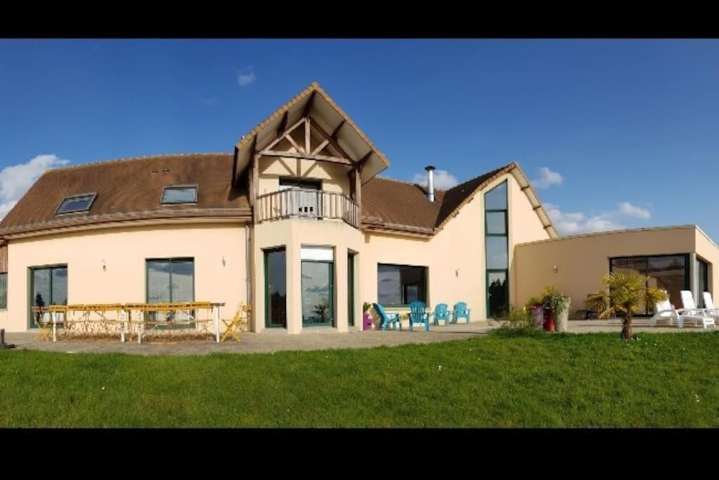 une grande maison blanche avec une table et des chaises dans l'établissement Magnifique villa avec piscine intérieure, à Saint-Pois
