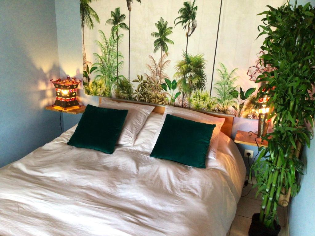 a bed with two green pillows in a room with plants at Maison d'une chambre avec jardin et wifi a Lectoure a 4 km de la plage in Lectoure