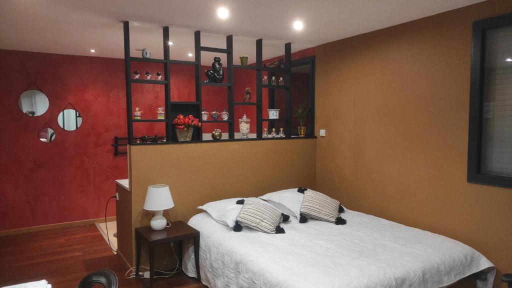 a bedroom with a white bed with red walls at Marie's Home in Saint-Péray