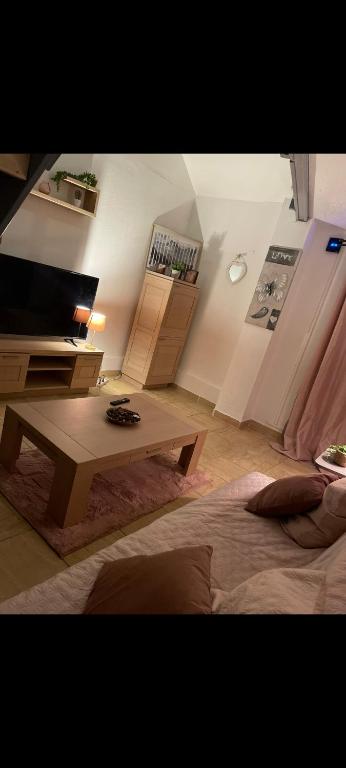 a living room with a bed and a coffee table at Appartement cosy à 5mn de la gare de denain. in Denain