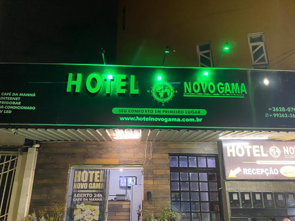 una señal de hotel frente a un edificio por la noche en Hotel Novo Gama en Novo Gama