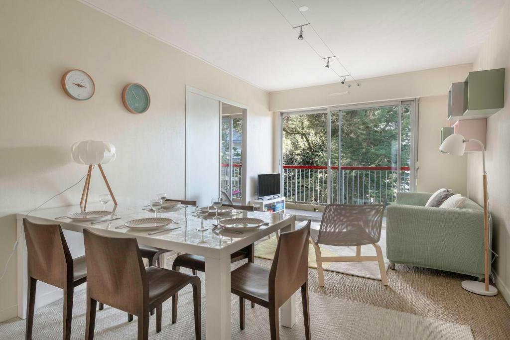 uma sala de estar com uma mesa de jantar e cadeiras em Charmant appartement a 200 m de la mer! em Pornichet