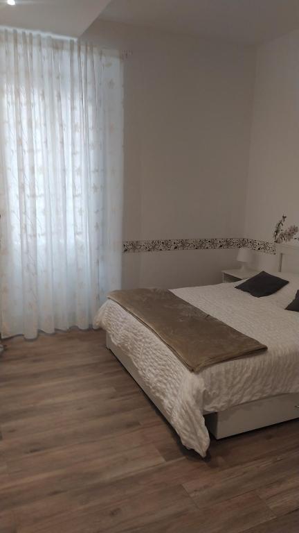 Schlafzimmer mit einem Bett mit weißen Vorhängen und Holzböden in der Unterkunft Vatican's apartment in Rom