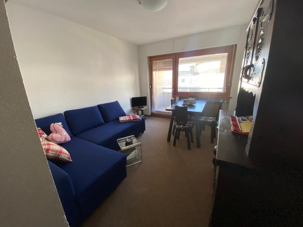 un soggiorno con divano blu e tavolo di BeSt Alce a Sestriere