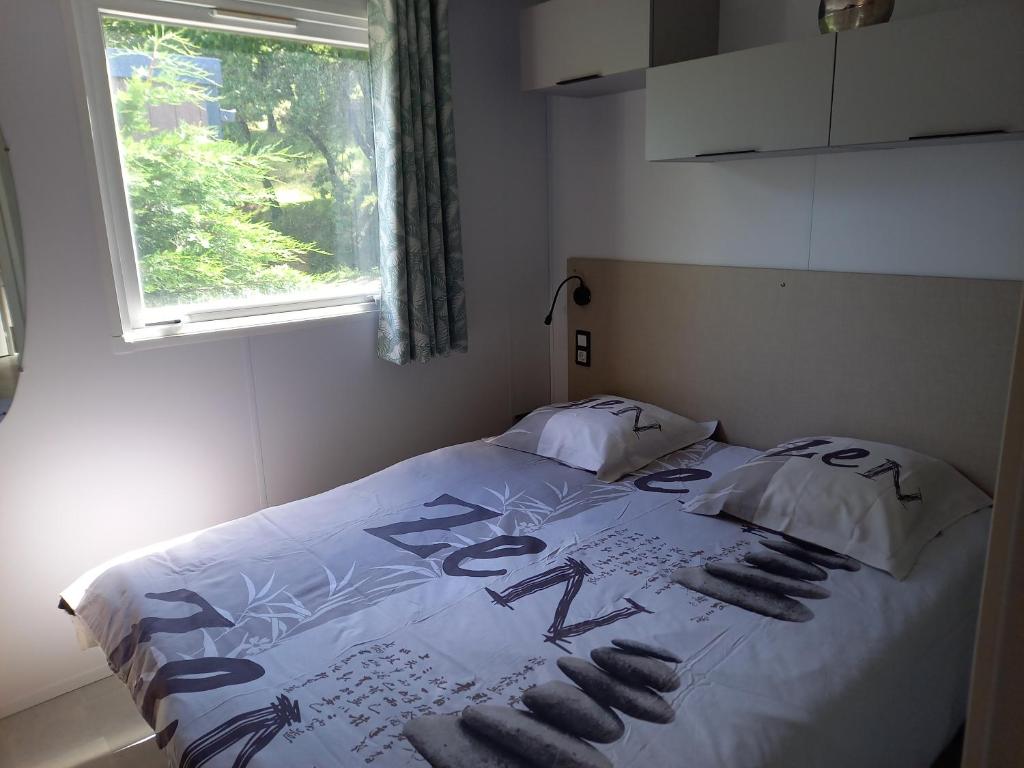 Un pat sau paturi într-o cameră la Mobil home yves et magali