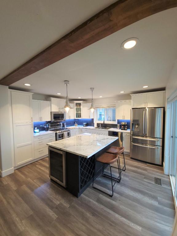 a large kitchen with a large island in the middle at Sunny Stays Family Pool Home, Golf, lake and vineyards near YLW and UBCO in Kelowna