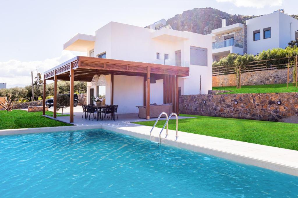 a villa with a swimming pool in front of a house at Luxury Villa U in Kokkini Khanion