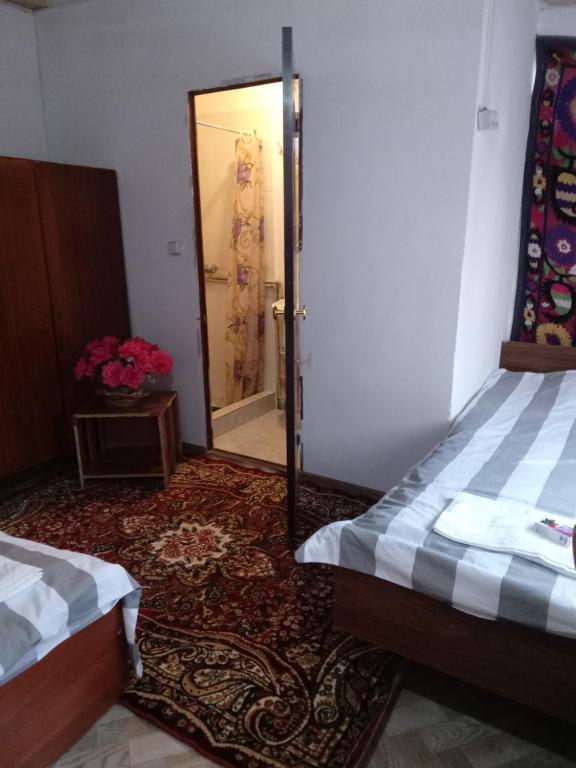 Habitación con 2 camas y puerta con espejo. en Sayfi Guesthouse, en Dushanbe