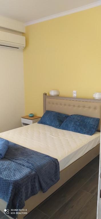 a bedroom with two beds with blue pillows at Giovanni Apartment 21 Kos in Kos Town