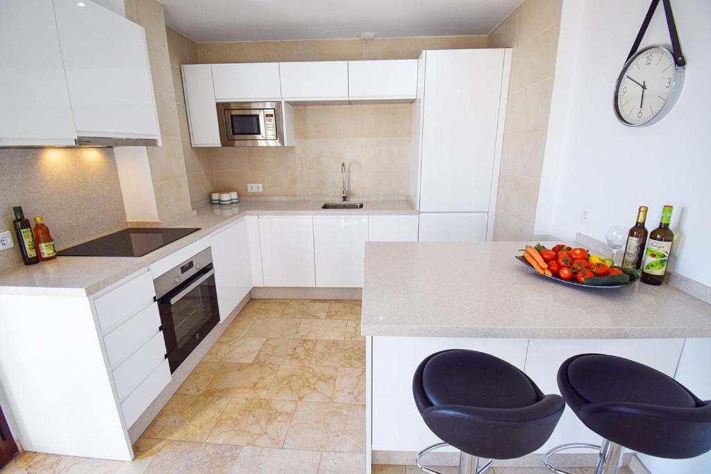 kuchnia z białymi szafkami i miską owoców na ladzie w obiekcie Penthouse 17A, Frigiliana 2 bedroom, Pool, Large Terrace and Amazing views in the center of Frigiliana HansOnHoliday Rentals w mieście Frigiliana