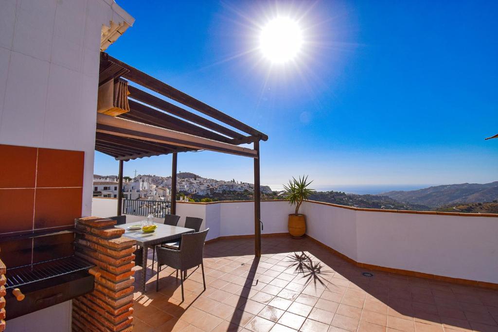 patio ze stołem i krzesłami na balkonie w obiekcie Penthouse 17A, Frigiliana 2 bedroom, Pool, Large Terrace and Amazing views in the center of Frigiliana HansOnHoliday Rentals w mieście Frigiliana