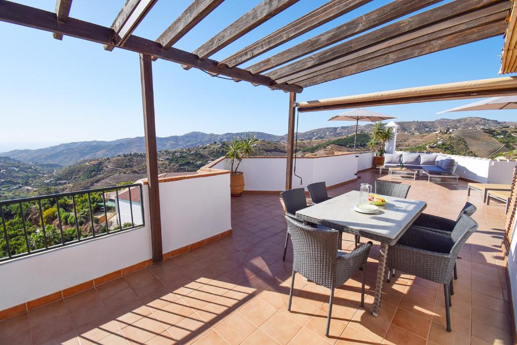jadalnia ze stołem i krzesłami na balkonie w obiekcie Penthouse 17A, Frigiliana 2 bedroom, Pool, Large Terrace and Amazing views in the center of Frigiliana HansOnHoliday Rentals w mieście Frigiliana