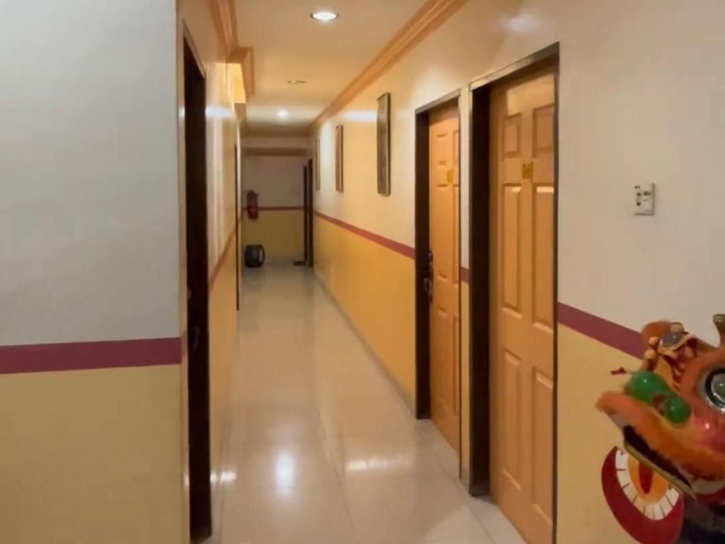 a hallway in a school with doors and a hallway at Hotel Langkap 冷甲酒店 in Kampung Degong