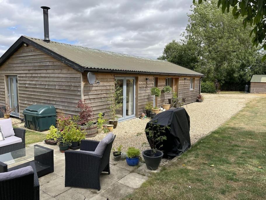 a house with a yard with chairs and a patio at The Lambing Lodge in Swanton Morley