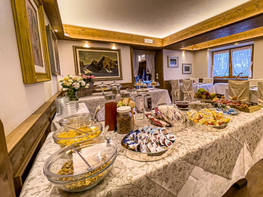 a long table with many plates of food on it at Hotel da Beppe Sello in Cortina dʼAmpezzo