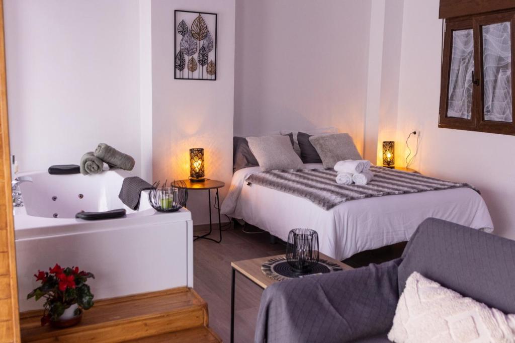 1 dormitorio pequeño con 1 cama y 1 sofá en Apartamento Villar, en Alcalá del Júcar