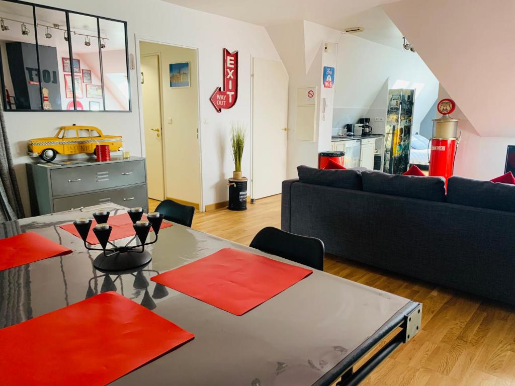 una sala de estar con una mesa y un sofá en Amiens LOFT, en Amiens