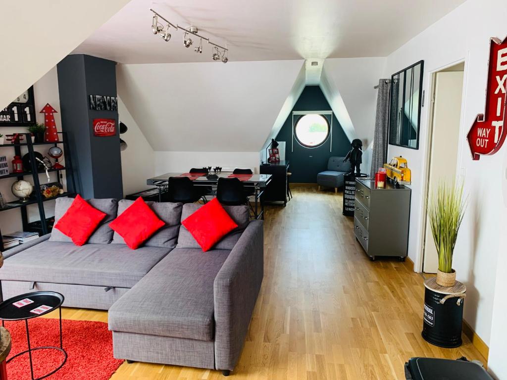 a living room with a gray couch with red pillows at Amiens LOFT in Amiens