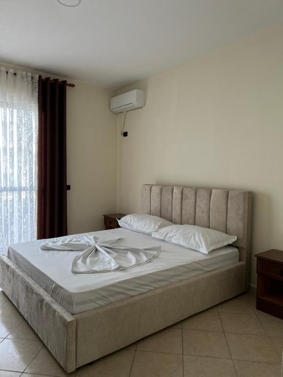 - une chambre avec un lit doté de draps blancs et une fenêtre dans l'établissement Hotel Antik, à Golem