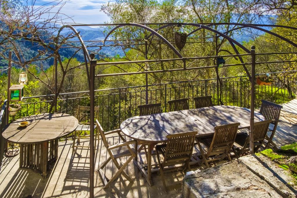 un patio con tavolo e sedie sul balcone. di Maison à Peille a Peille