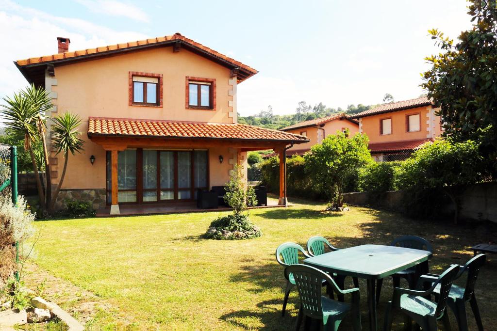 una mesa y sillas en el patio de una casa en Casa Sofía, en San Vicente de la Barquera