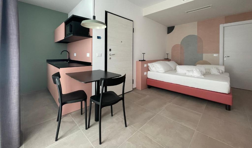 Arqué Apartments - Arco Centro في آركو: غرفة نوم بسرير وطاولة وكراسي